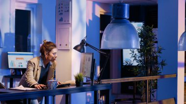 Yönetici yöneticisi bilgisayardaki şemaları analiz ediyor ve son teslim tarihinden önce finansal rapor projesini bitiriyor. Ekonomi grafiklerine ve pazarlama analizlerine bakan kadın danışman.