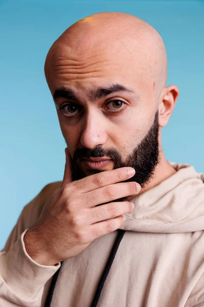 沉思的Arab男人一边揉着下巴 一边用迷惑的表情看着相机 多愁善感的阿拉伯人用不确定的情感作画来做决定和解决问题 — 图库照片