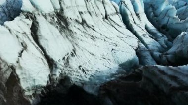Vatnajokull Buzulu 'nun insansız hava aracı görüntüleri, güzel mavi buz blokları, yarıklar ve karlı dağların yakınındaki buzdağları. Gölde yüzen buzlu devasa kayalar. 60 fps video.