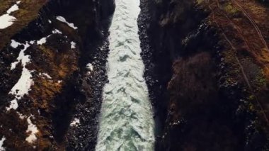 İzlanda 'da büyük bir Gullfoss şelalesi, İzlanda kanyonu kayaları ve tepeleri arasında akan güzel bir şelale. Kuzey nehri kayalıklardan aşağı akıyor. 60 fps video.