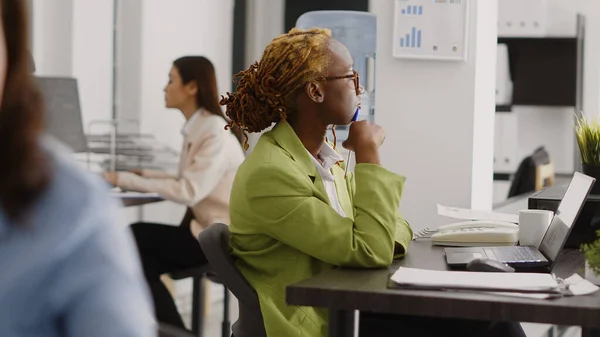 アフリカ系アメリカ人は 企業のオフィスで利益を上げるためのビジネスソリューションを考えています 女性従業員は 開発のためのマーケティングビジョンを作成するための新しいアイデアをブレーンストーミング — ストック写真