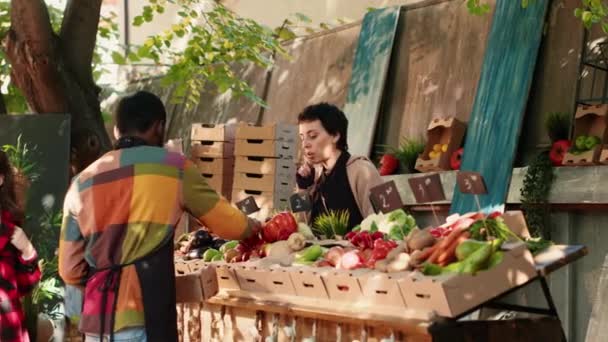 Разнообразная Команда Фермеров Помогает Клиентам Выбирать Органические Продукты Продавая Доморощенные — стоковое видео