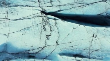 Dikey video: İzlanda 'daki Vatnajokull buz kütlesinin hava görüntüsü, büyük yarıkları ve buz mağaraları olan güzel İzlanda buzulu. Kuzey manzarasında mavi elmas şekilli buzdağları. 60 fps video.
