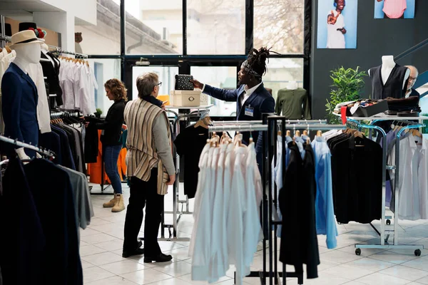 Funcionário Showroom Ajudando Mulher Sênior Escolher Saco Comprando Roupas Casuais — Fotografia de Stock