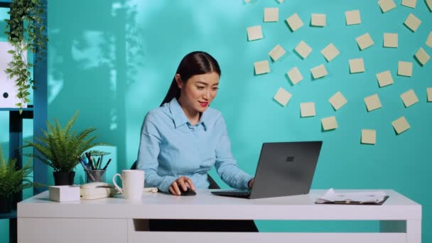欣喜若狂的上班族 为公司的成功欢呼雀跃 快乐快乐的女商人在蓝色工作室背景的色彩斑斓的办公桌前欢呼 — 图库视频影像