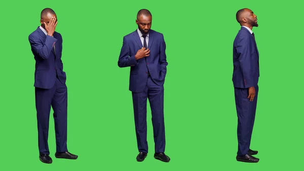 アフリカ系アメリカ人の男性が何かを待っていて 全身の緑の背景の上に立っています 男性スタートアップの従業員はせっかちで カメラにペーシング 正式なビジネスマン — ストック写真