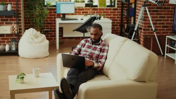프리랜서는 집에서 일하는 노트북에 데이터를 프리칸 미국인 소파에 멋지고 아파트 — 비디오