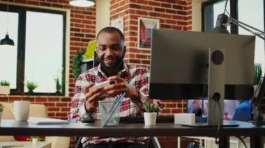 Mutlu rekabetçi oyuncular akıllı telefondan video oyunu oynuyorlar, eğleniyorlar. Neşeli adam rahat, şık, sıcak apartman dairesinde telefonda eğleniyor.