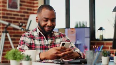 Mutlu bir insan telefonda online arkadaşlarıyla sohbet ediyor, şık bir evde kendini eğlendiriyor. Afrika kökenli Amerikalı bir adam sosyal medya yayını ve el kamerasıyla onu eğlendiriyordu.