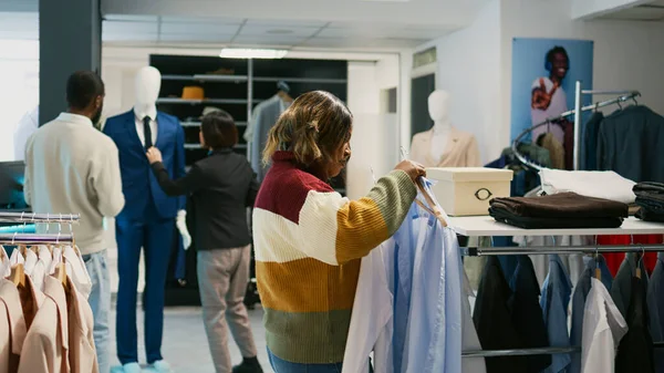 現代のクライアントのシャツの衣料品店では 正式な服のための若い女性のショッピングワードローブを高めるためにぶら下がっ見て ショッピングセンターの顧客は 現代的なファッションコレクションを購入 — ストック写真