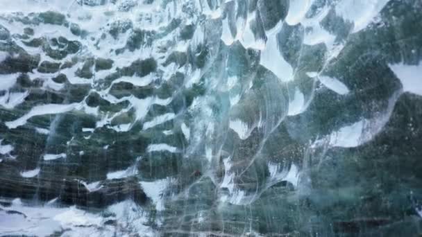 巨大的冰块在裂缝中 透明的冰川冰洞在冰原 美丽的蓝色冰川在寒冷冰冻的小径上 结冰的岩石被霜冻覆盖 纹理开裂 手持射击 — 图库视频影像