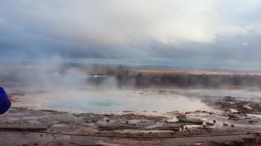 Reykjavik yakınlarındaki panoramik manzarada İzlanda gayzerleri, deliklerin püskürmesi ve sıcak su ve buharla güzel bir çeşme oluşturması. İzlanda 'da jeti ve manzarası olan İskandinav krateri. El kamerasıyla..