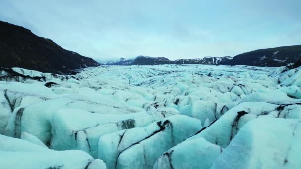 凍ったアイスランドの水の周りに浮かぶ壮大なVatnajokull氷河 青と緑の色の美しい氷のブロック 氷の岩や氷山と風光明媚なルートのドローンショット スローモーション — ストック動画