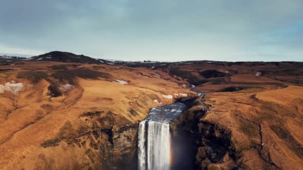 在冰原上的大瀑布拍下了鼓声 水流从美丽的棕色悬崖上流下 宏伟的冰山一角 从山上掉下来 形成了壮观的风景 慢动作 — 图库视频影像