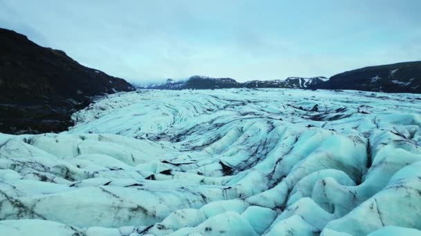 空中俯瞰冰川冠 冰岛景观中结冰湖上形成的天然蓝色冰川泻湖 巨大的北极冰山漂浮在冰冷的土地上慢动作 — 图库视频影像