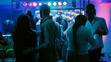 Mutlu insanlar slow müzik dansını seviyorlar, diskotekte parti yapıyorlar. Erkekler ve kadınlar çiftler halinde dans eder ve romantik anlarda eğlenirler, gece hayatı eğlencesi. El kamerasıyla..