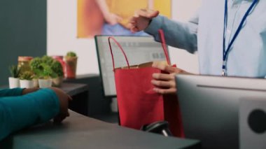 Modern butikte alışveriş sırasında ödeme terminalini kullanarak son moda ürünlere kredi kartıyla ödeme yapan Afrikalı Amerikalı bir müşteri. Alışverişkolik kadın giyim mağazasından günlük kıyafet alıyor..