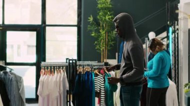 Afrikalı Amerikalı soyguncu şık kıyafetler çalıyor, alışveriş merkezinden kaçmaya çalışıyor. Asyalı koruma butik kapısında hırsızı yakalayıp şık kıyafetleri iade etmesini yoksa polisi arayacağını söyledi.