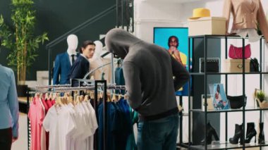 Asyalı koruma tarafından yakalanan hırsız modern butikten moda kıyafetler çalmaya çalışıyor. Afro-Amerikalı çift, mağaza çalışanı ve güvenlik görevlisiyle tartışıyor ve suçtan kaçmaya çalışıyor.