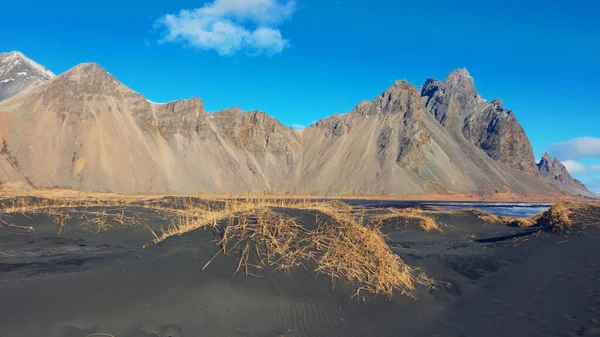 巨大な山のチェーンは 黒砂のビーチと海 雄大なアイスランドの風景を満たしています ベストラホーン山脈と自然の風光明媚なルートと北欧のストックスネス半島 手持ち撮影 — ストック写真
