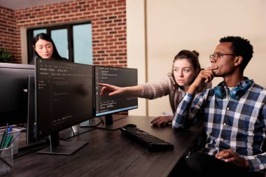 Yazılım geliştiricisi, terminal penceresindeki veritabanı betiğine bakarak html kodu için kodlayıcı istiyor. Veri odasında uygulama geliştirme programı üzerinde çalışan programlama mühendisleri ekibi.