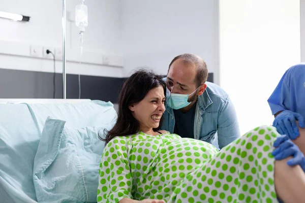 孕妇分娩时的推挤和尖叫 得到丈夫和医院团队的医疗支持 在产科医院分娩时 未来的母亲会有痛苦的宫缩 — 图库照片