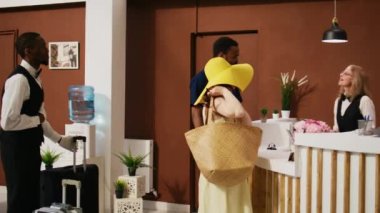 Otelden ayrılan turistler, balayı gezilerini resepsiyonistlere giriş kartı verip çıkış işlemlerini yaptıktan sonra bitiriyorlar. Otel müşterileri lobide ayrılıyor. El kamerasıyla..