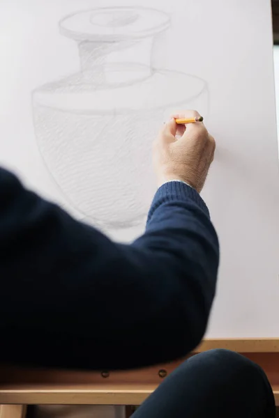 キャンバスに鉛筆でシニア男性の手描きのクローズアップ スケッチや描画する方法を学びます アートクラスに出席 アトリエや工房で活動しながら花瓶のスケッチを制作 — ストック写真