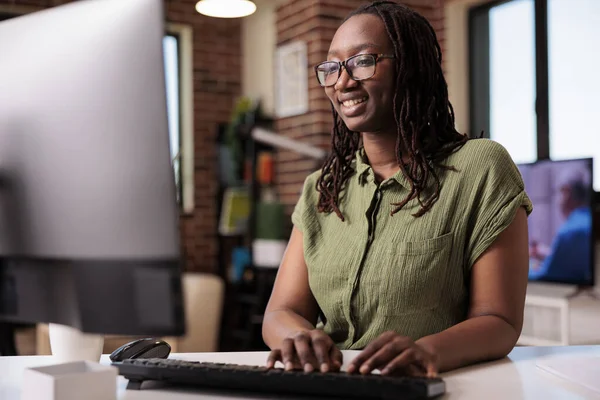 아프리카 미국인 프로그래머가 키보드로 타이핑하는 컴퓨터 화면에서 재밌는 내용을 보면서 — 스톡 사진