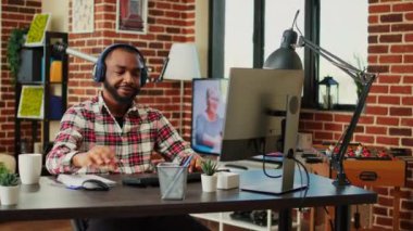 Evde çalışırken kulaklıkla müzik dinleyen neşeli, uzaktan kumandalı bir işçi. Gülümseyen serbest yazar keyfine bakıyor, bilgisayar başında şık bir hoş geldin bürosunda yazı yazıyor.