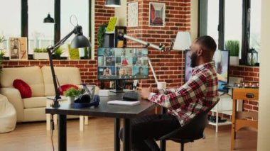 Memleketten çalışırken çeşitli uluslararası takımlarla sohbet eden neşeli bir çalışan. Samimi apartmandan iş arkadaşlarıyla çevrimiçi video görüşmesi yapan bir adam.