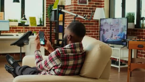 Ενθουσιασμένος Αφροαμερικανός Που Παίζει Διαστημικό Παιχνίδι Σκοποβολής Smartphone Χρησιμοποιώντας Λειτουργία — Αρχείο Βίντεο