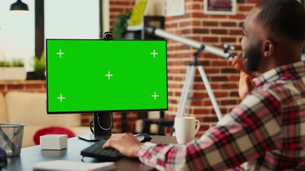 クロマキーを見てビデオ通話セッションで同僚とオンラインで議論している従業員は コンピュータの緑の画面をモックアップします 自宅から遠隔作業でオンライン会議中のテレワーカー — ストック動画