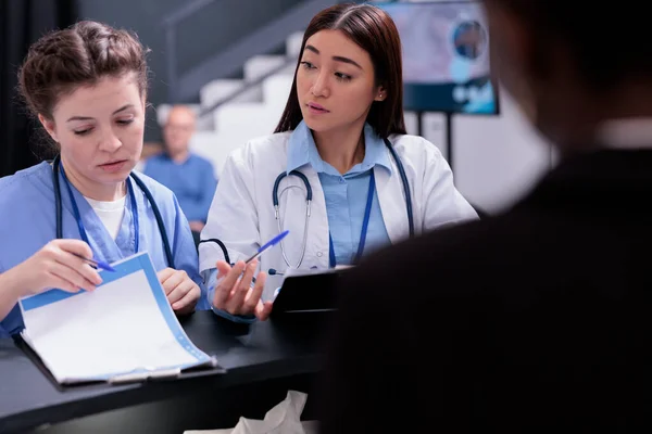 Diverse Medical Staff Standing Reception Desk Discussing Patient Symptoms While — Stock Photo, Image