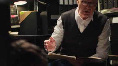 Suç delillerini ortaya çıkarmak için kayıtlarla çalışan iki dedektif ve tanık ifadelerini okuyarak dava şüphelisine karşı sağlam bir dava oluşturuyorlar. Görevli özel dedektifler. El kamerasıyla..