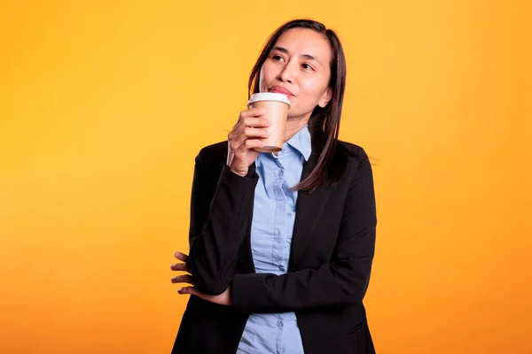 Positive Asiatische Frau Genießt Heißen Cappucino Studio Posiert Vor Gelbem — Stockfoto