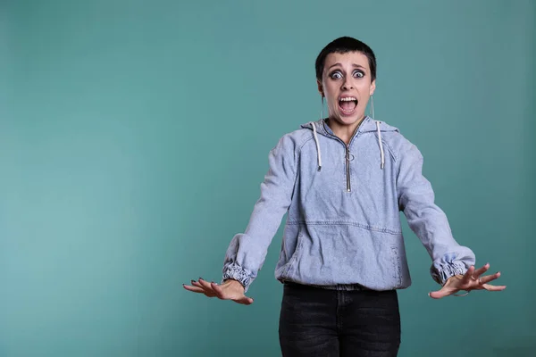 Afraid terrified woman having scared expression after hearing the bad news, nervous person standing in studio posing over isolated background. Frightened female looking at camera with shock reaction
