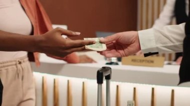 Müşteri hizmetleri aldıktan sonra otel müşterilerine bahşiş vermek. Afrikalı Amerikalı kadın bagaj taşımasına yardım ettiği için hamal işçiye dolar banknotu veriyor.