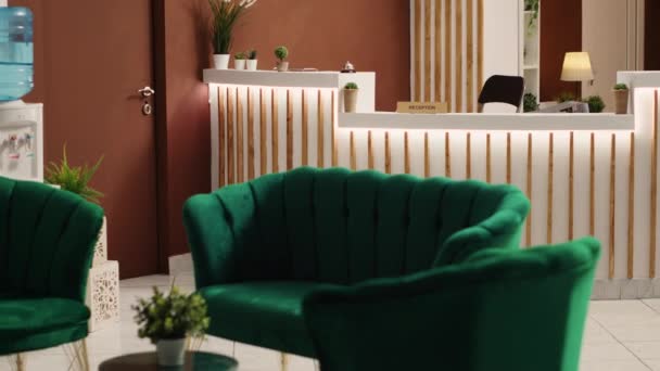 豪華な緑の椅子と到着ゲストのための準備ができてソファ付きのスタイリッシュな素朴な歓迎ホテルラウンジのインテリア 旅行休暇の宿泊施設カウンターデスクでチェック スローモーション — ストック動画