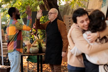 Yaşlı emekli çiftçi mutlu müşteriye beşlik çakıyor, yerel pazarda toplanıyor. Sahibi, düzenli memnun müşterilere taze organik sebze ve meyve satıyor. Dostça gülümseyen yerel satıcılar.