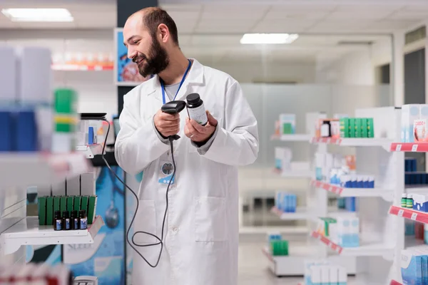 Кавказский Фармацевт Работая Аптеке Держит Штрих Код Сканирующей Бутылки Лекарствами — стоковое фото