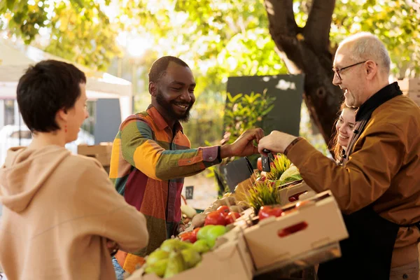 年长的卖主将苹果样本送给男性顾客 客户试用生物有机新鲜水果和蔬菜 在农场摊位销售有机生态产品的小企业主 — 图库照片