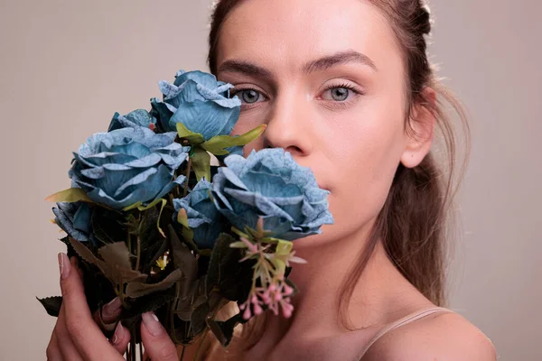 漂亮的金发女子展示玫瑰花束的肖像 美丽的年轻女子 蓝眼睛 手里拿着富有创意的花朵 手拿着礼物 紧盯着相机 — 图库照片