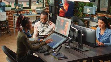 Team of african american people brainstorming game production ideas, looking at artistic development software. Creative agency colleagues analyzing CGI technique to create 3D modern project.