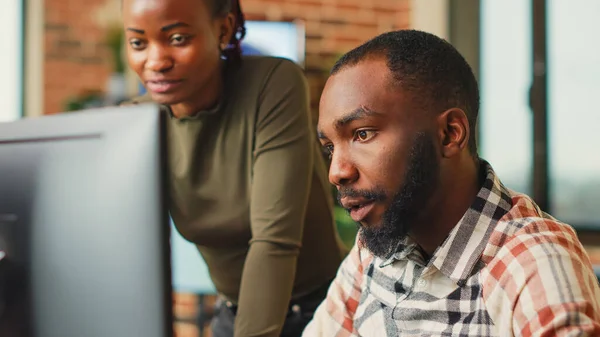 African american team of engineers working with 3d modelling software, brainstorming new ideas. Man and woman colleagues using artificial intelligence to create digital project at job.