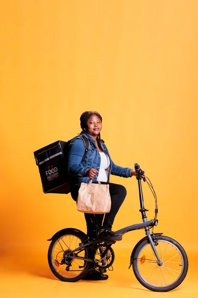 Pizzeria Çalışanı Elinde Fast Food Siparişiyle Kese Kağıdı Tutarken Bisikletle — Stok fotoğraf