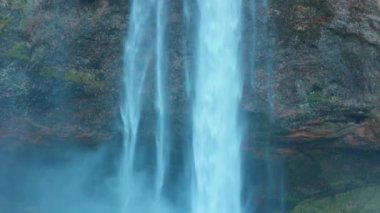 İzlanda 'daki şelale, İzlanda' daki kayalıklardan düşen seljalandsfoss şelalesi. İskandinav manzaralı güzel nehir tepeden aşağı akıyor, muhteşem panoramik manzara.