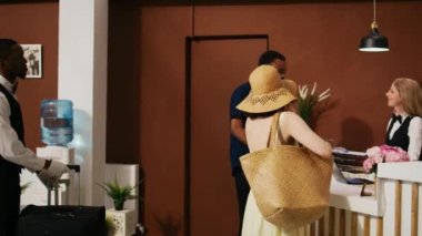 Lobideki resepsiyonistten giriş kartı alan turistler kayıt işlemlerini tamamlıyorlar. Otel personeli, balayında çift olarak giriş yapmak için mükemmel bir hizmet sunuyor. El kamerasıyla..