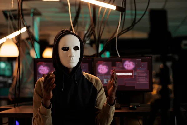 アフリカ系アメリカ人のハッカーは 匿名のマスクを着用し ランサムウェアを要求して 夜にビデオを放送します トロイの木馬ウイルスやコンピュータマルウェアでデータベース情報を盗む男性スパイ — ストック写真