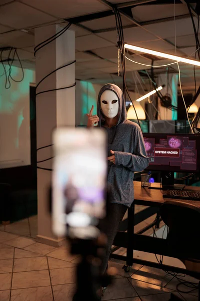 匿名のマスクでサイバー犯罪者がランサムウェアビデオを記録し ライブ放送でオンライン脅威を作り出します ウイルス暗号化でサーバーに侵入する危険なスパイインターネット詐欺を犯す — ストック写真